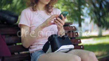 年轻女子在公园里使用<strong>头戴式</strong>显示器。 玩游戏使用VR<strong>头</strong>盔智能手机。 快乐